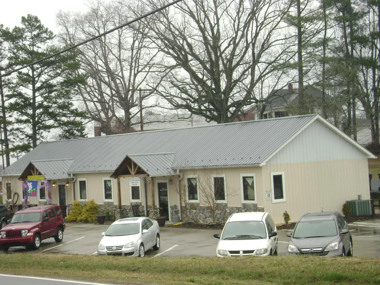 Gray metal roof with timber entry brackets on a small commercial building in Hiram