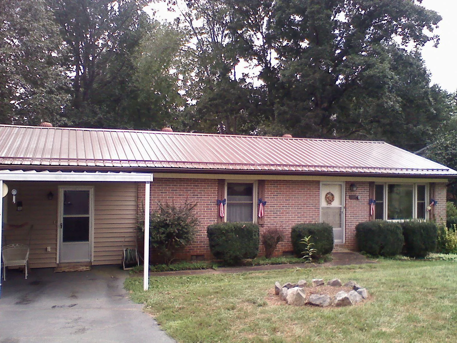 Bronze metal roof and carport on a brick ranch home — Roof Repair work by our crew in Hiram