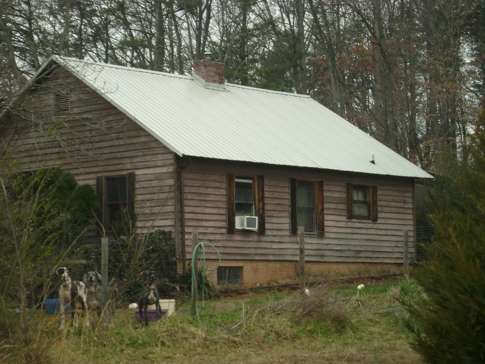 White metal roof on an old wood sided farmhouse, from a Metal Roof Installation job in Hiram